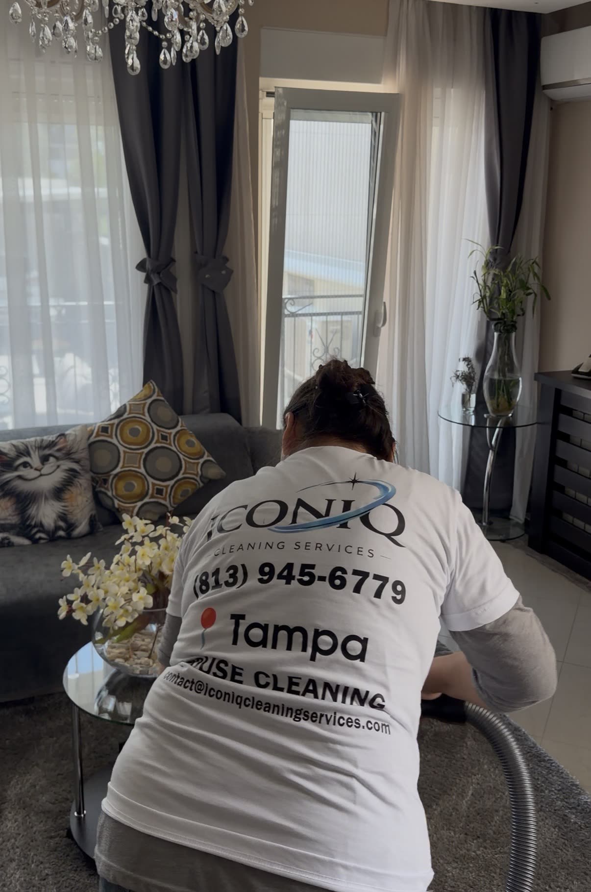 Iconiq cleaner vacuuming a bright Tampa living room
