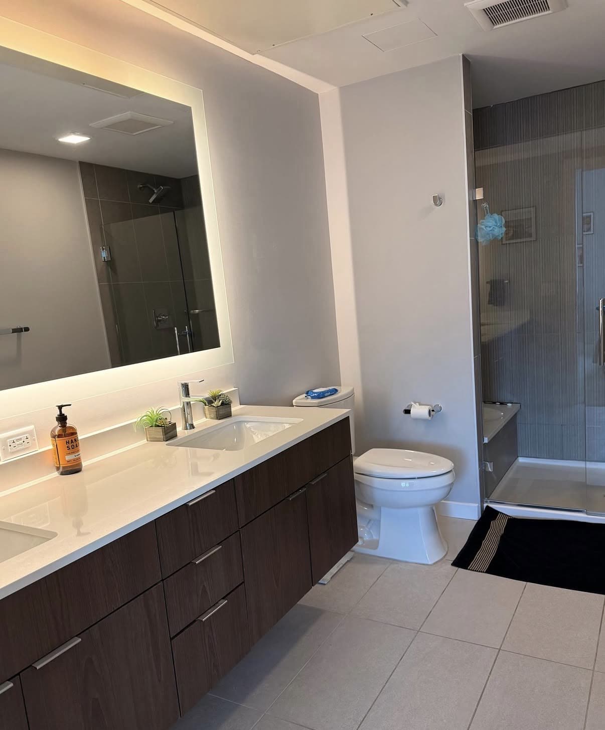 Sparkling double-vanity bathroom with backlit mirror after an Iconiq clean