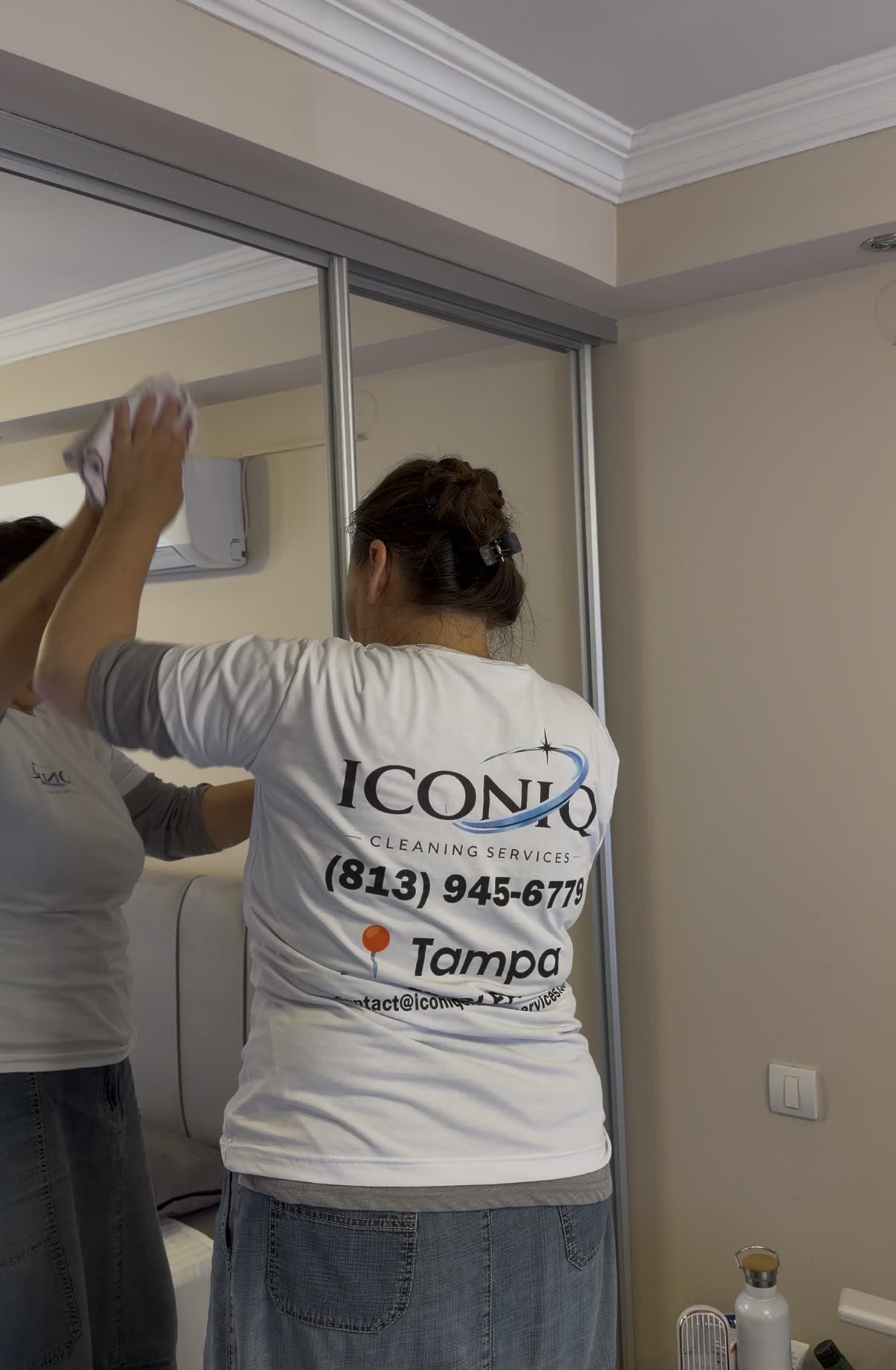 Iconiq cleaner polishing a bedroom mirror in a Tampa apartment