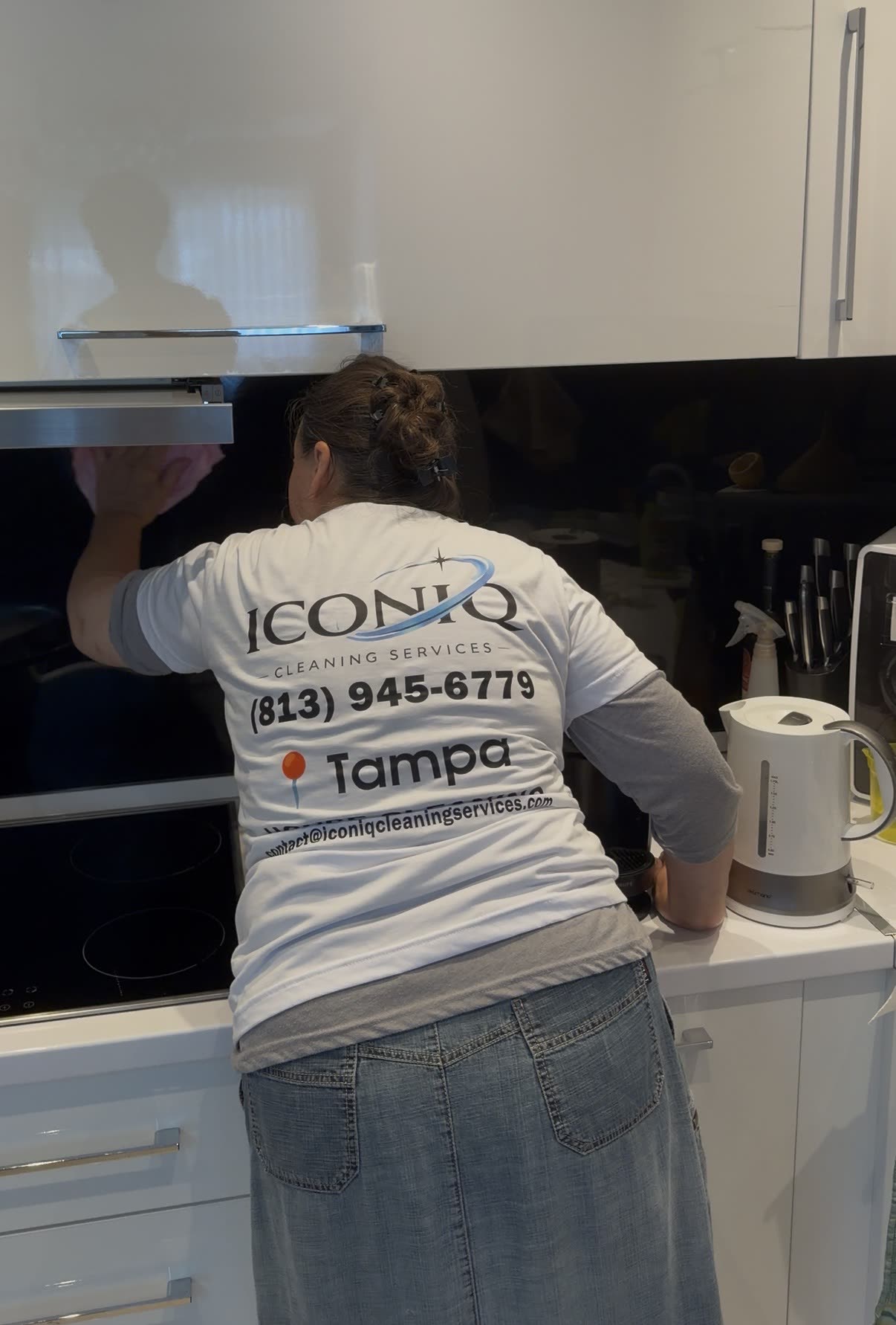 Professional Iconiq cleaner in uniform detailing a modern Tampa kitchen